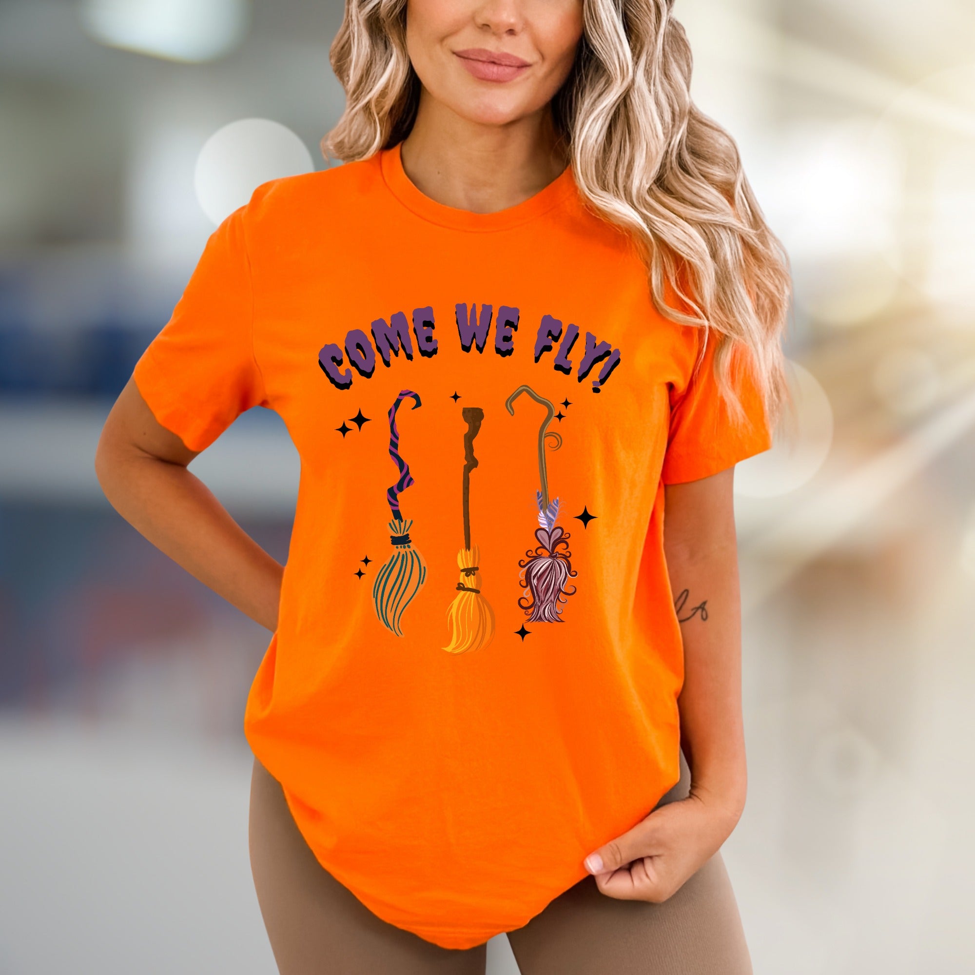 "COME WE FLY!" Witchy Broomstick Graphic Tee, a Spooky Chic Pick for Halloween Enthusiasts